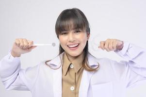 Una joven dentista sonriendo sobre un estudio de fondo blanco foto