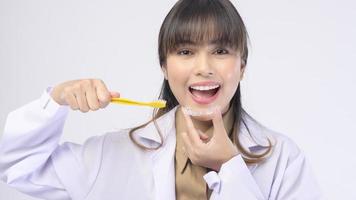 Una joven dentista sonriendo sobre un estudio de fondo blanco foto