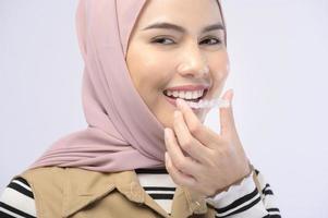 A young muslim woman holding invisalign braces in studio, dental healthcare and Orthodontic concept.. photo