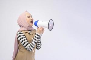 mujer musulmana feliz está anunciando con megáfono sobre fondo blanco foto