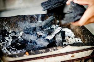 carbones ardientes para asar a la parrilla, humo blanco foto