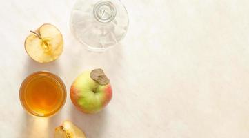 a glass of apple juice, apples and empty decanter on a white background.Top view,copy space. photo