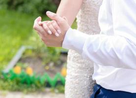 Wedding couple holds hands while dancing. photo
