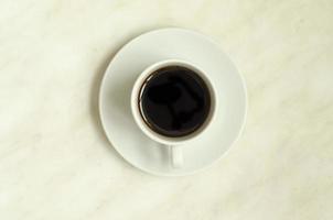 Top view, a cup of coffee on white surface.Morning coffee photo