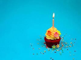 cupcake de feliz cumpleaños y vela de arco sobre fondo azul con espacio para copiar, lindo pastel en la fiesta de cumpleaños. foto