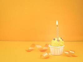 Sweet cupcake with bow candle on yellow background with copy space. Happy birthday party concept background. photo