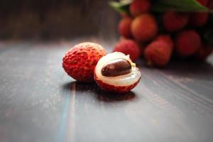 Fresh lychee fruits Litchi with leaves on wooden table photo