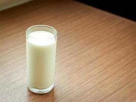 Glass of milk on a wooden table, healthy food photo