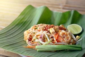 Delicious seafood Pad Thai stir-fried rice noodle on green banana leaf, one of the most popular favorite Thai street food. photo