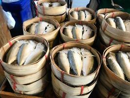 pescados de caballa al vapor tailandeses en una cesta de bambú a la venta en el mercado. foto