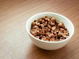 Cereal chocolate flavor in whith bowl on wooden table, breakfast ready to eat in the morning photo