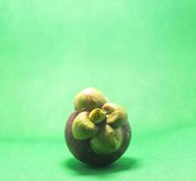 Mangosteen is the queen of Thai fruits. It is a seasonal fruit, popularly consumed and consumed as organic, non-toxic fruit, exported throughout Asia and Europe on a green background photo