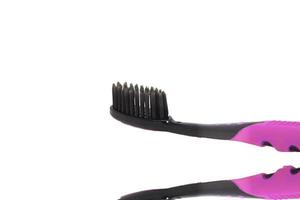 Charcoal toothbrush on a white background that cleans teeth with charcoal, designed for health-conscious people, environmentally friendly. photo