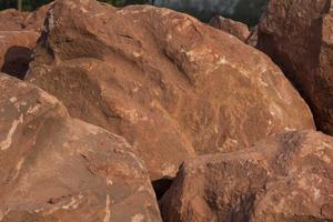 Brown mountain sandstone with large chunks of patterns, designed to be like nature by heavy machinery, beautifully crafted in a vast lakeside garden, perfect for relaxing and watching nature in summer photo