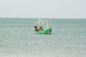 small fishing boat that catches fish and squid along the coast in a traditional way and maintains an ecosystem of fish and marine life for a long time on strong and windy days. photo