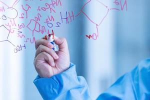 The scientists, chemists, researcher discover the chemical formula write on whiteboard in laboratory. The researcher discover vaccine or drug for treatment patients infected COVID19. photo