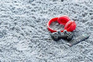 Gamer devices for playing game by joystick with computer headphone and remote control television, gaming and esports challenge, streaming lying on grey carpet background photo