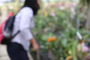 Blurred photography , a lady is watching orchids in plant market, Thailand. photo