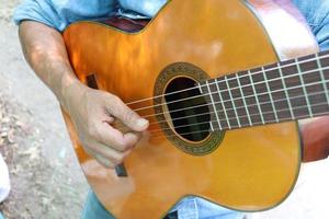 A man is playing guitar. Hand is playing yellow guitar. photo