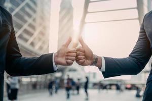 Businessman in suit handshake together for successful in city and walking people background. photo