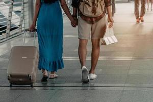 la gente y el equipaje de viaje sostienen un mapa caminando en el fondo del aeropuerto. foto