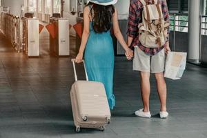 la gente y el equipaje de viaje sostienen un mapa caminando en el fondo del aeropuerto. foto