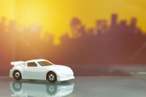 juguete de coche de lujo blanco enfoque selectivo en el fondo de la ciudad borrosa foto
