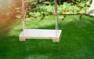 Wooden swings on blur green garden background photo