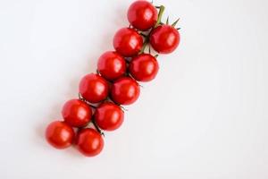 Fresh red delicious cherry tomatoes on white background. Summer agriculture. Italian cousine.Shallow DOF, selective focus image. photo