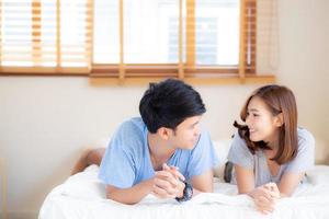 Beautiful portrait young asian couple relax and satisfied together in bedroom at home, family lying on bed confident with cheerful and happy with relationship, man and woman dating. photo