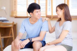 Beautiful portrait young asian couple relax and satisfied together in bedroom at home, family sitting on bed confident with cheerful and happy with relationship, man and woman dating. photo