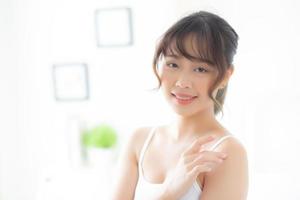 Beautiful asian woman applying cream and treatment for skin care touch on shoulder, asia girl with lotion spa and moisturizing for health and wellness body part, lifestyle and beauty cosmetic concept. photo