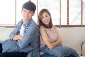 Beautiful portrait young asian couple relax and satisfied together in living room at home, family sitting couch confident with cheerful and happy with relationship, man and woman dating. photo