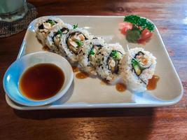 californian sushi roll on plate with soyu photo
