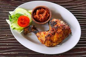 aesthetic honey roasted chicken with vegetables, Asian cuisine menu Balinese and Indonesian food on wooden background photo
