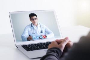 conceptos de medicina en línea, comunicación con pacientes a través de redes en línea, tecnología y atención médica. haga una videollamada con un médico en su computadora portátil. foto