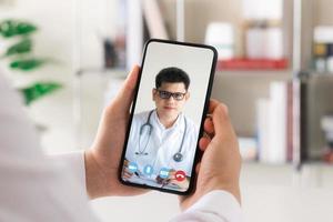 conceptos de medicina en línea, comunicación con pacientes a través de redes en línea, tecnología y atención médica. haga una videollamada con un médico en su teléfono inteligente. foto