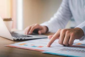 Businessman analyzing company's financial balance sheet working with digital augmented reality graphics. Businessman calculates financial data for long-term investment. photo