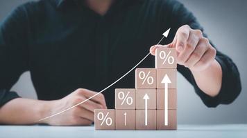 Interest rate and dividend concept, wooden block with percentage symbol and up arrow, return on stocks and mutual funds, long term investment for retirement. photo