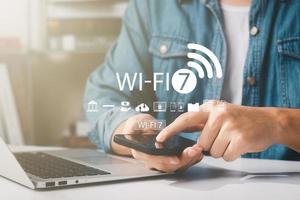 hombre usando un teléfono inteligente con tecnología wifi 7, conectándose al mundo de Internet con nueva tecnología. foto