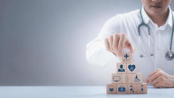 Doctor arranged wooden block with icons of medical, health check and healthcare, digital future healthcare. photo