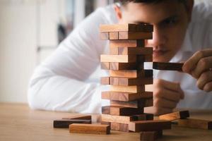Business management concepts and business strategies, executive hands pulling out wooden blocks, expressing corporate vision, preventing risks from future crises. photo
