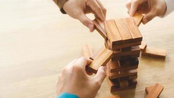 Business management concepts and business strategies, a team of young geniuses playing wooden games, expressing corporate vision, preventing risks from future crises. photo