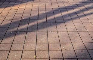 sombras de personas en una zona comercial europea en un suelo de adoquines foto