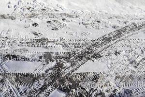 Tire Tracks on snow covered streets in a close up view. photo