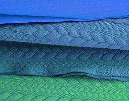 Detailed close up view on samples of cloth and fabrics in different colors found at a fabrics market photo