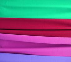 Detailed close up view on samples of cloth and fabrics in different colors found at a fabrics market photo