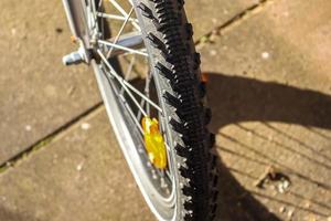 Selective focus close up view at a bicycle wheel with metal spokes. photo