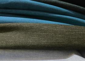 Detailed close up view on samples of cloth and fabrics in different colors found at a fabrics market photo