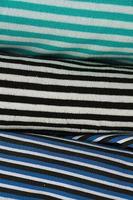 Detailed close up view on samples of cloth and fabrics in different colors found at a fabrics market photo
